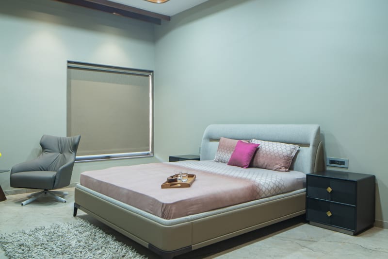 "Minimalist bed with pink pillows and headboard"