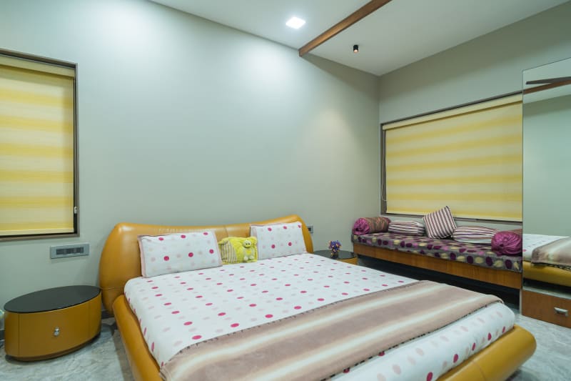 "Modern bedroom with yellow bed frame and daybed"