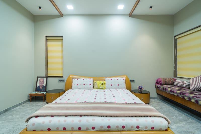 "Symmetrical view of bedroom with yellow bed"