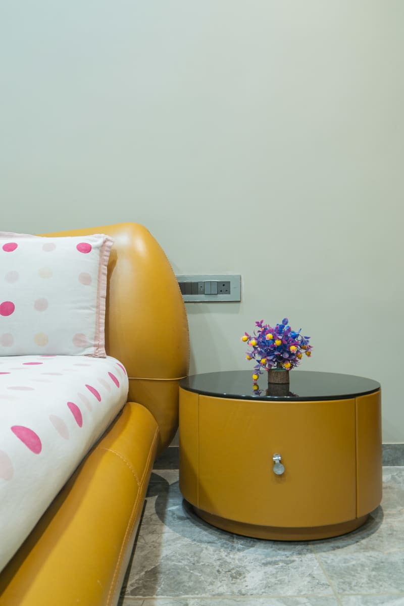 "Round yellow bedside table with small flowers"