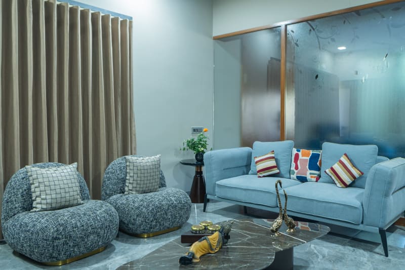 "Blue sofa and grey armchairs in living room"