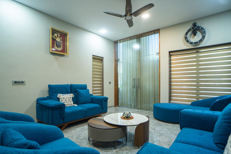 "Spacious living room with dark blue sofas""