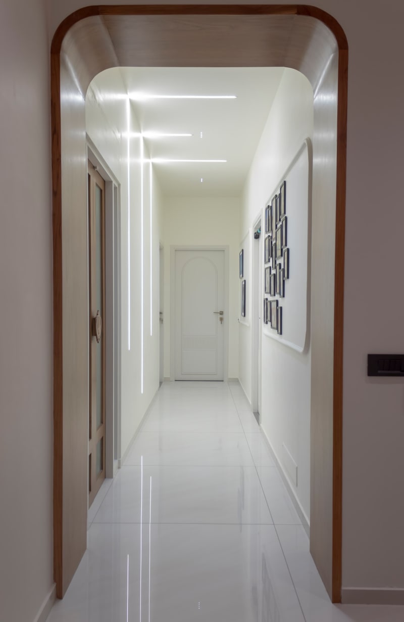 Curved wooden archway leading into white corridor