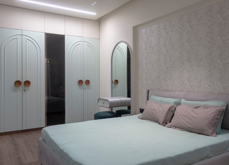 Mint green bedroom wardrobe and bed view