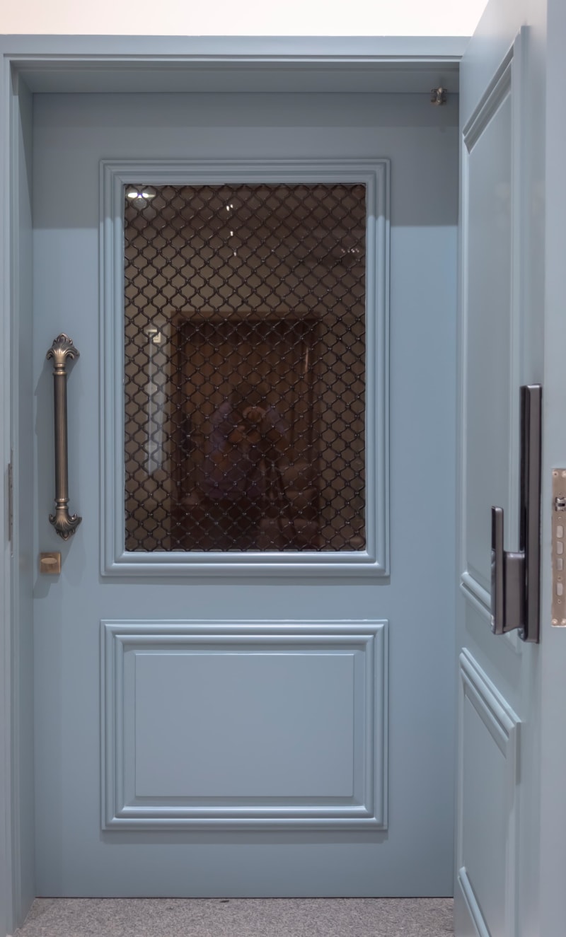 Light blue wooden door with grill
