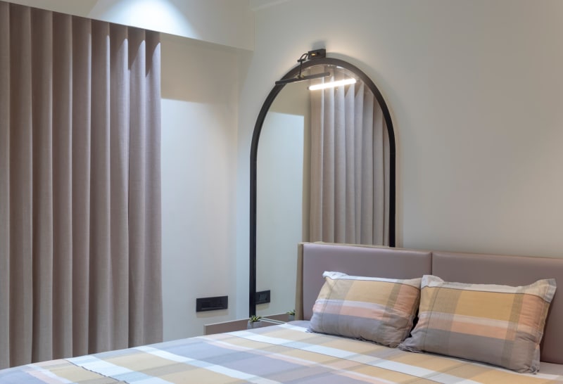 Arched mirror above bed in modern bedroom