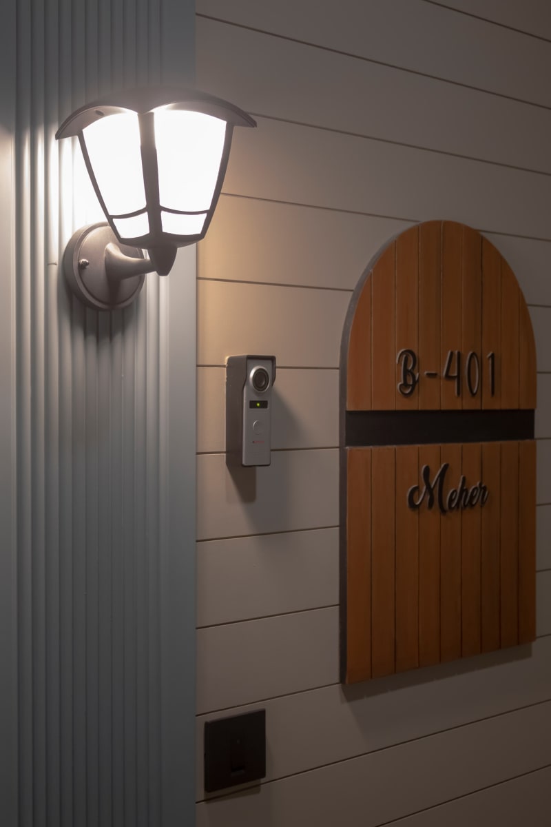 Entrance nameplate next to a wall light