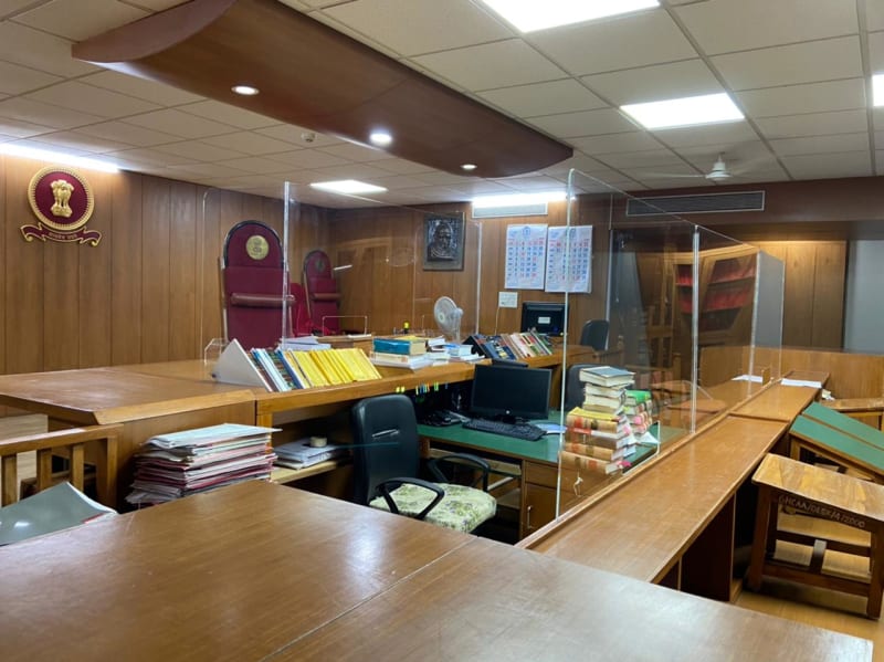 Wood-paneled courtroom with judge's chair and emblem