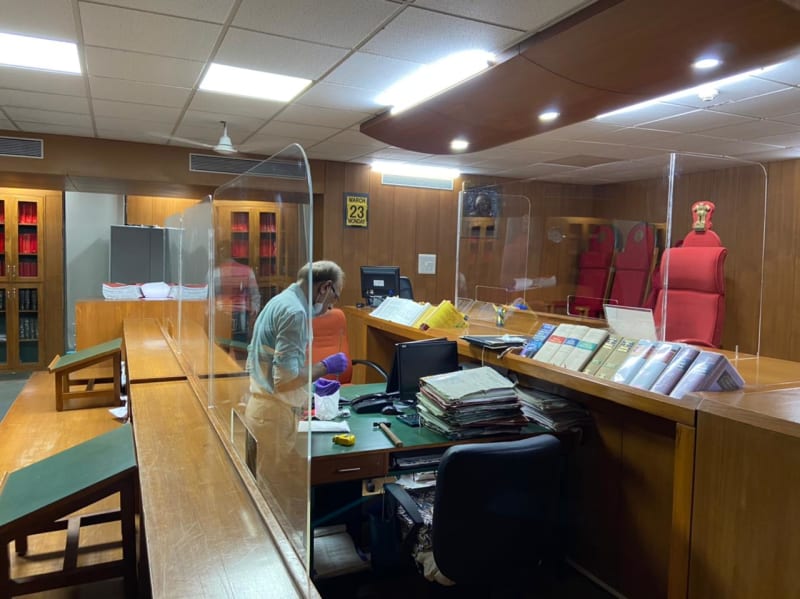 Wood-paneled courtroom with staff at desks