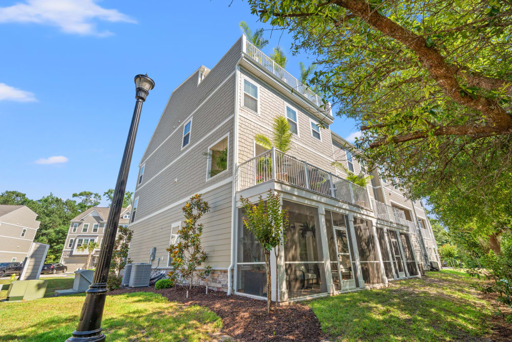 Rear view showing the screened porch, lanai, and rooftop deck stacked on three floors