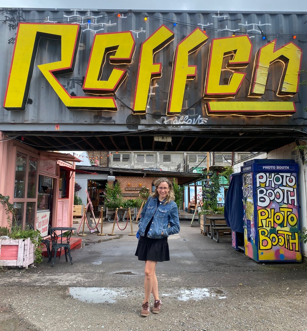 Refshaleøen sign at the entrance to the creative district near Christiania in Copenhagen with a visitor standing underneath