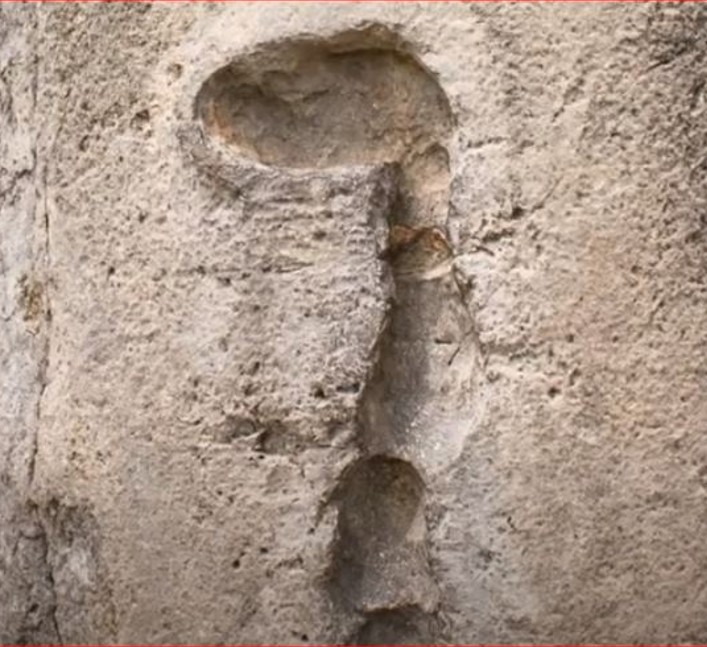 "Close-up detail of the precise Inca stonework at Sacsayhuamán, Peru, showing a large boulder with carved protrusions and perfectly fitted joints between massive stones."