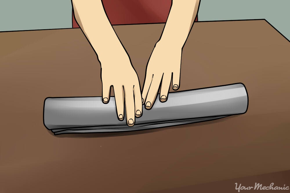 https://res.cloudinary.com/yourmechanic/image/upload/dpr_auto,f_auto,q_auto/v1/article_images/11_How_to_Sit_in_a_Car_Without_Back_Pain_Hands_rolling_up_a_hand_towel