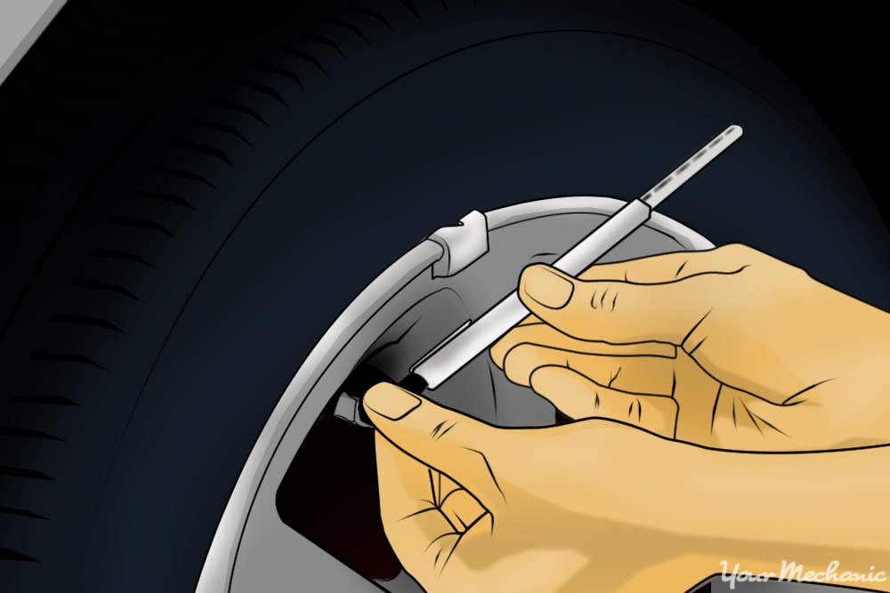 hands checking tire pressure gauge