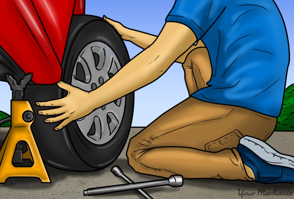 person replacing tire with spare