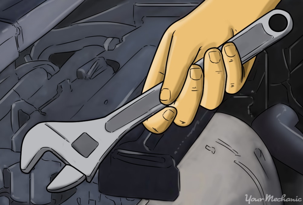 a hand holding a wrench with a vehicle engine in the background