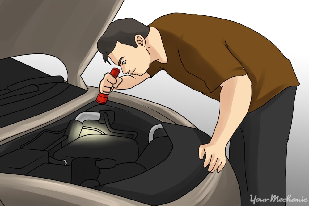 person inspecting engine with a flashlight