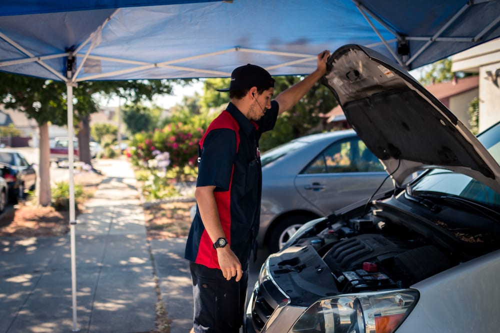 mechanic looking into car