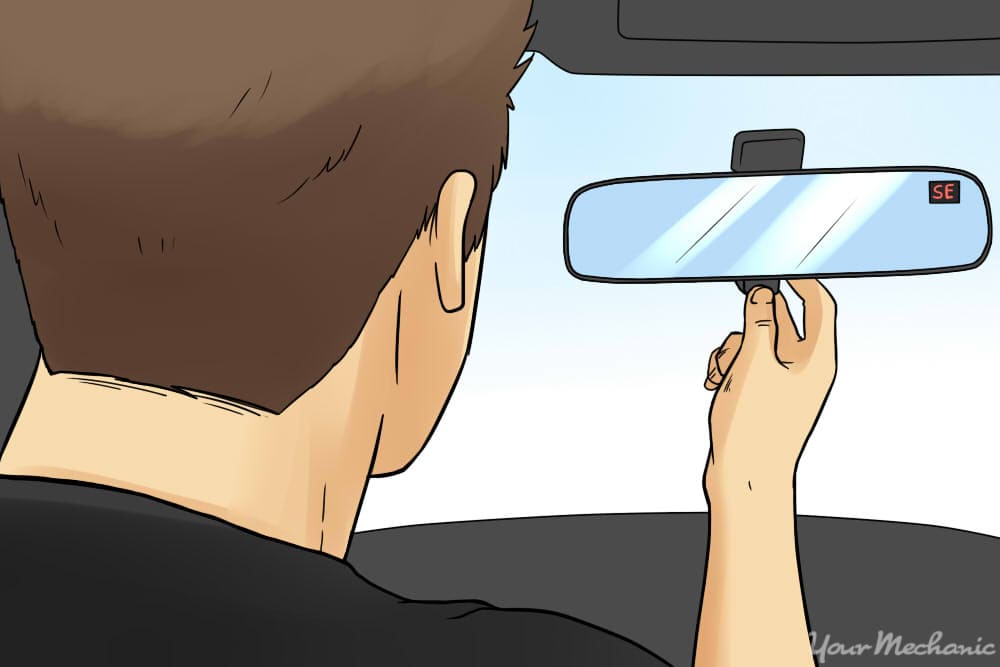 person looking into rearview mirror compass