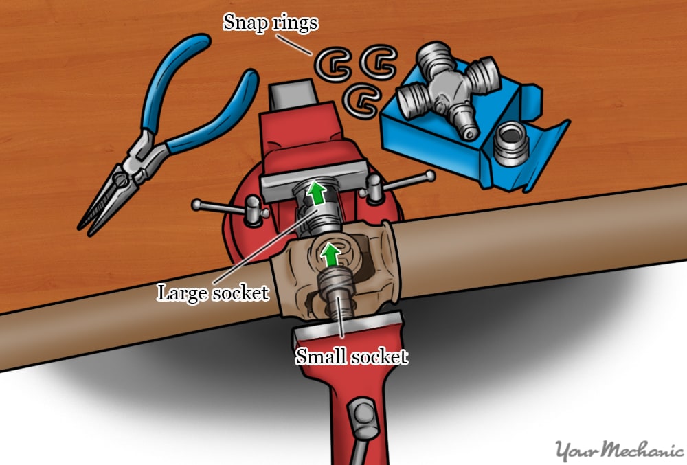 vise and sockets to force joint out of driveshaft yoke