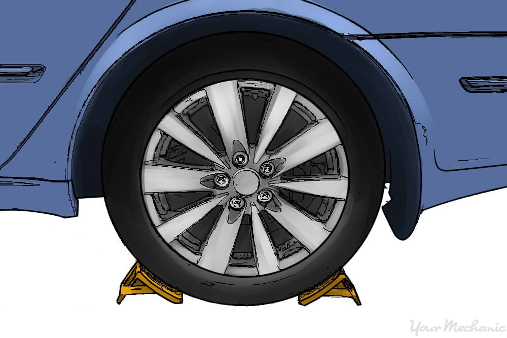 vehicle parked on a level surface with wheel chocks around the rear tire