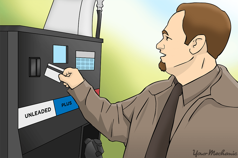 man inserting card into gas pump