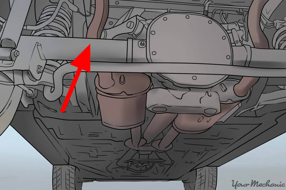 arrow pointing at cylindrical shaft underneath the car