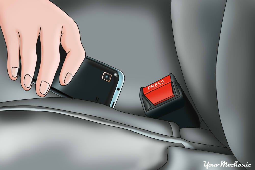 hand pushing phone between cushing