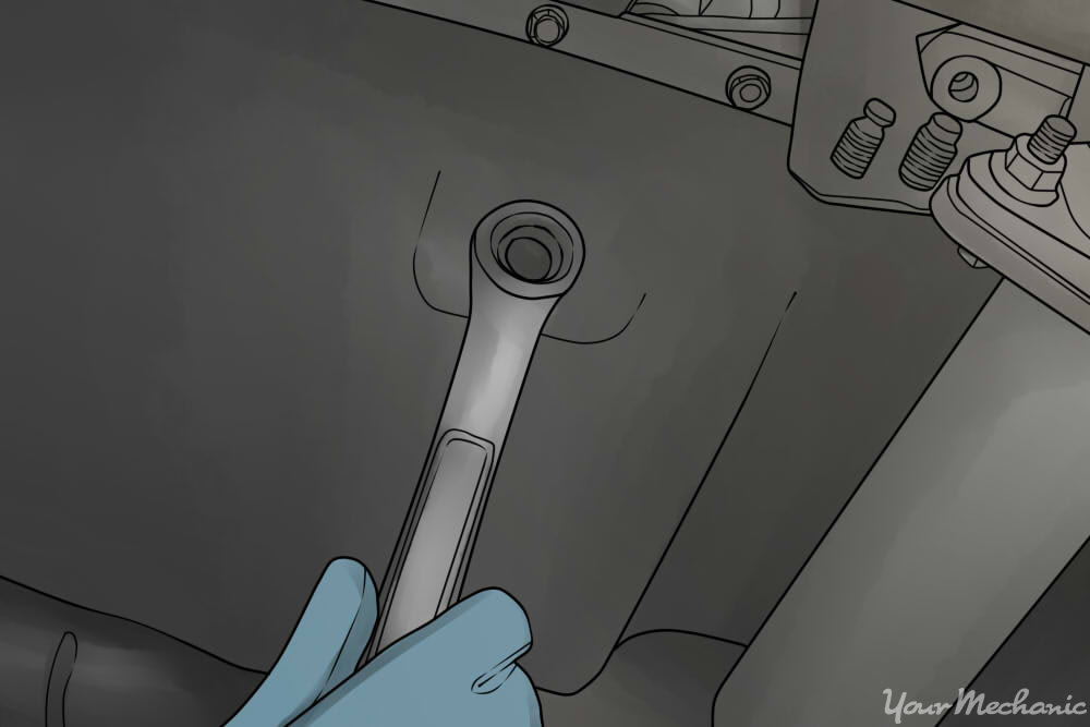 removing oil pan drain plug with a wrench