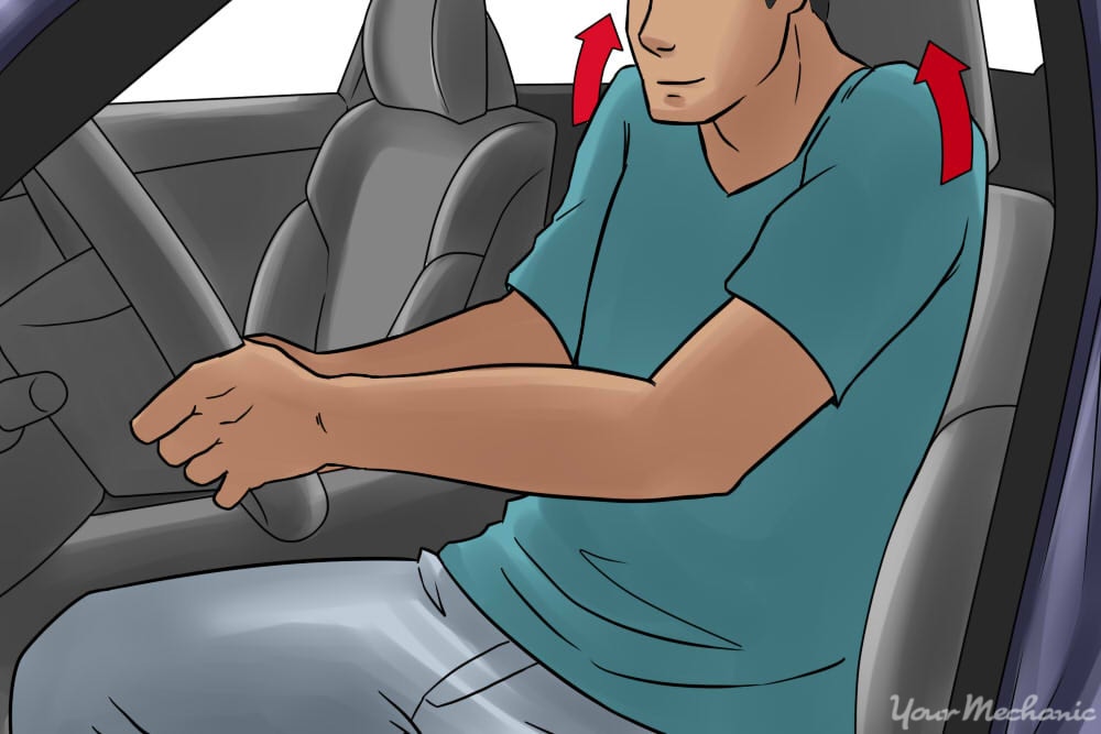 person rolling their shoulders sitting in car