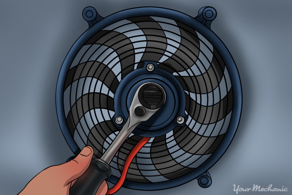 hand using ratchet removing retaining nut on cooling radiator fan blade