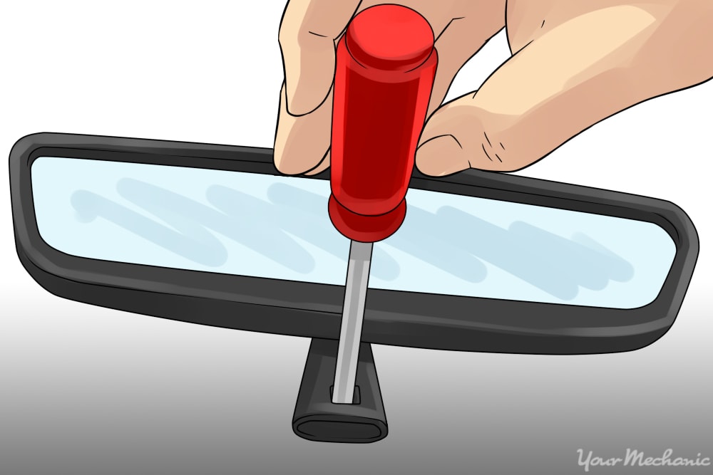 using a screwderiver to remove the mounting screw on a rearview mirror