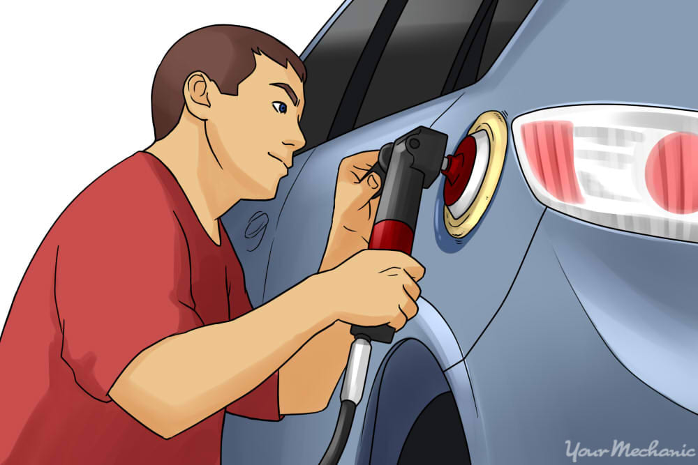 person buffing out car paying attention to detail