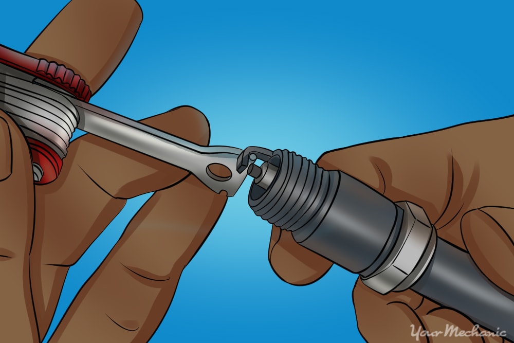 hand measuring spark plug gap