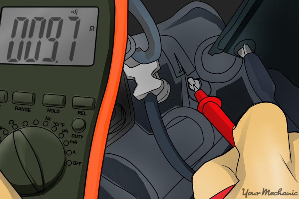 person touching positive lead of multimeter to terminal