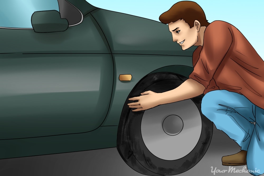 person inspecting tires of car