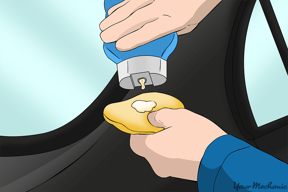 person applying cleaner wax to an applicator