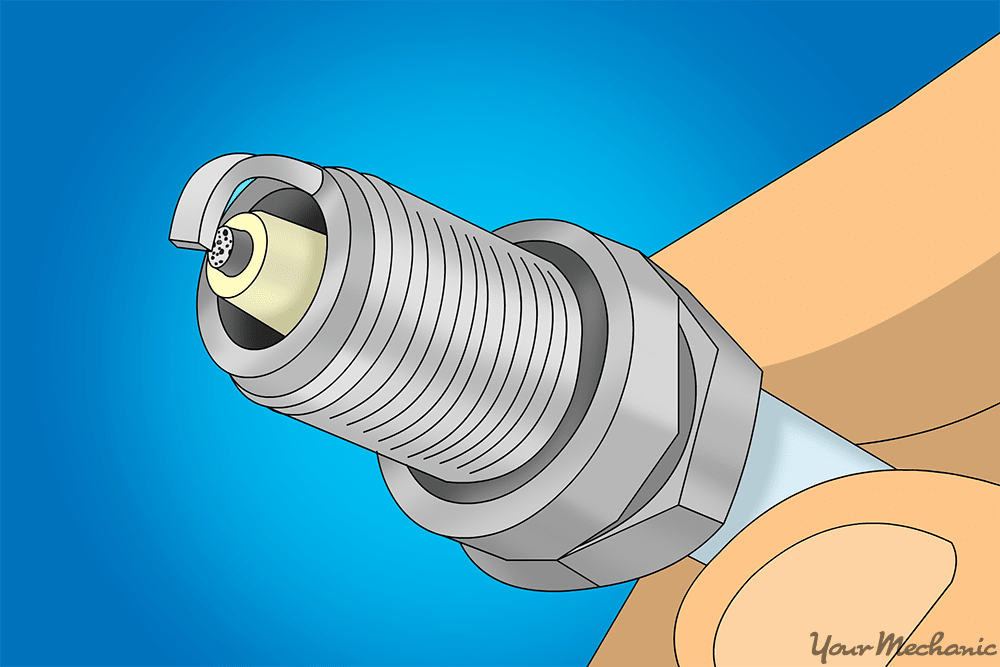 spark plug with black peppering over plug