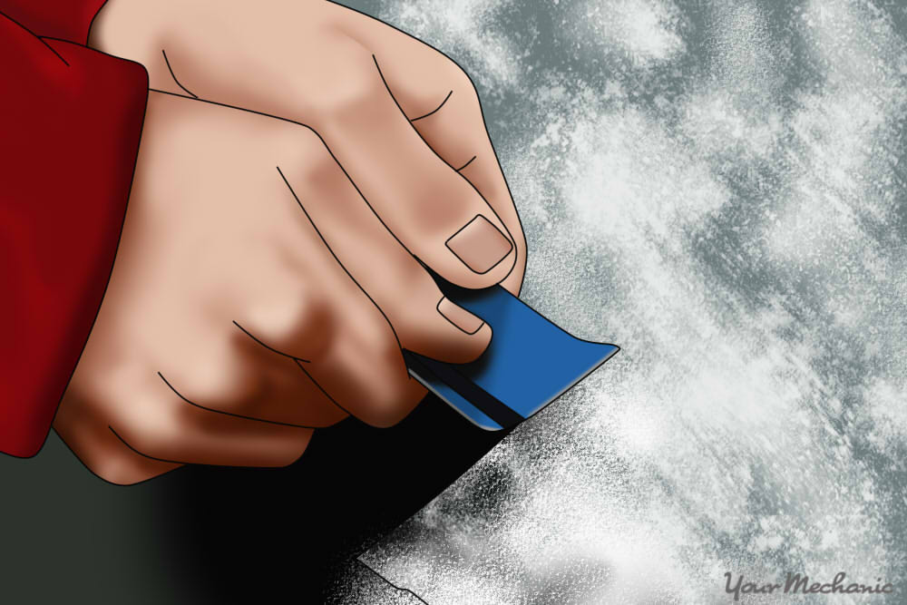 hand using credit card to scrape away a window frost