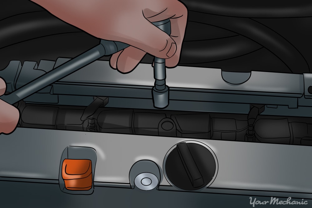 an ignition coil bolt being removed from an engine