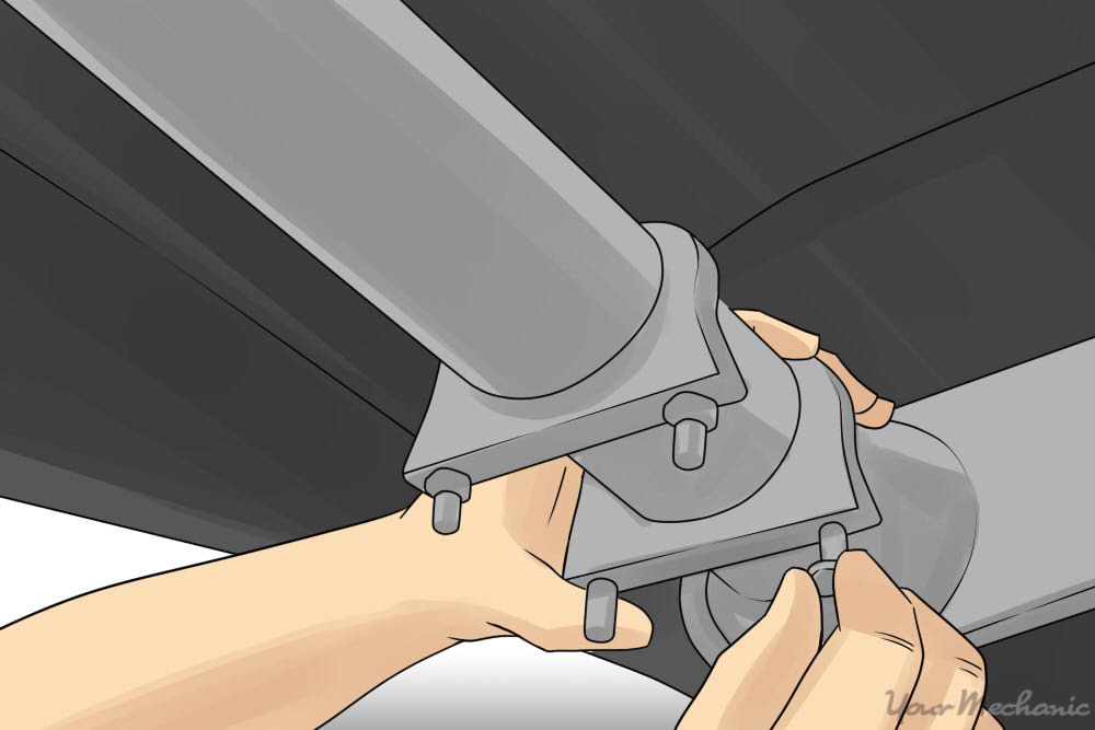 hand prying an exhaust clamp