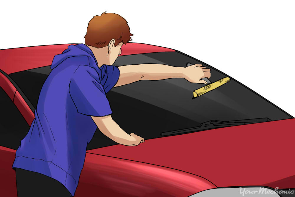 How to Fix Squeaky Windshield Wiper Blades - person cleaning windshield