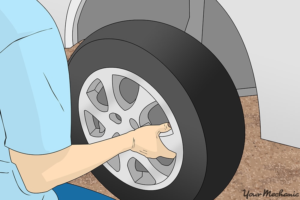 mechanic removing wheel from vehicle