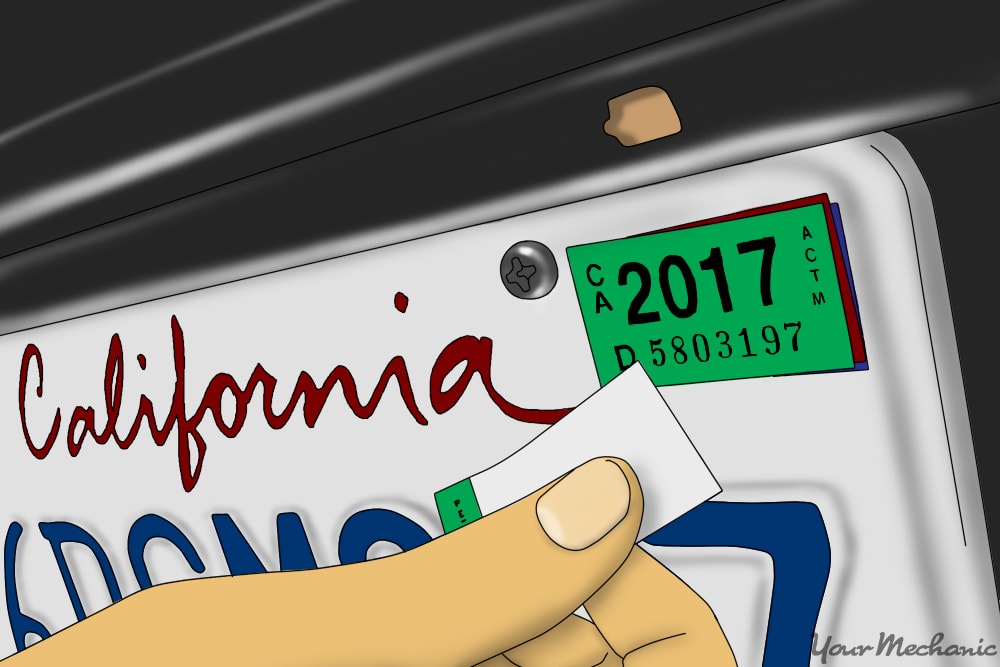 person putting registration sticker on license plate