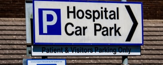 An image showing a road sign directing to parking at a UK hospital