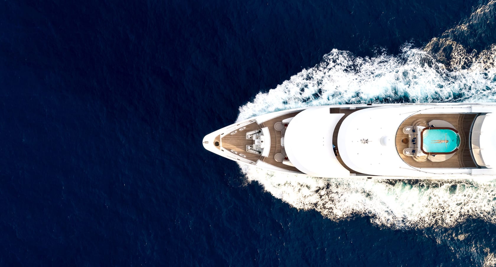 Superyacht charter - aerial view of a superyacht cruising through the water