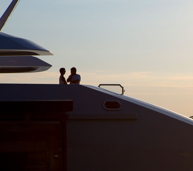 Crew members onboard a superyacht at sunset