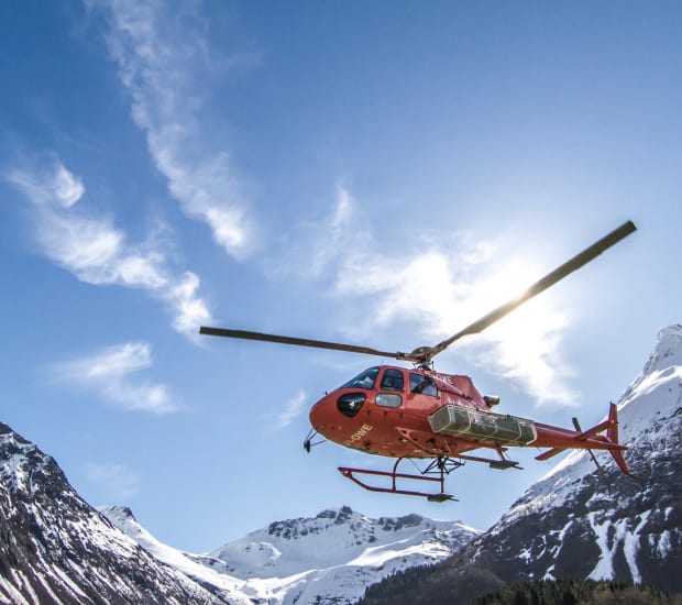 Helicopter flying over snowy mountains