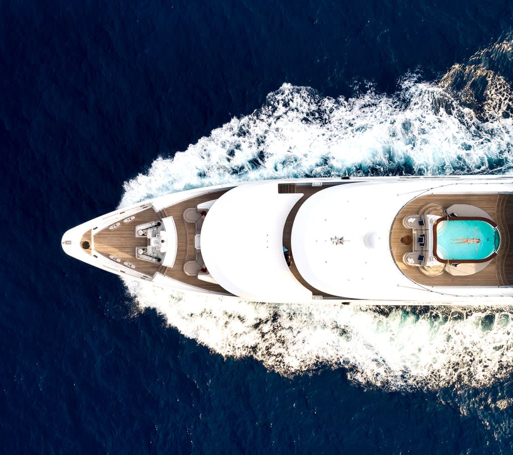 Arial view of a yacht cutting through the dark blue sea