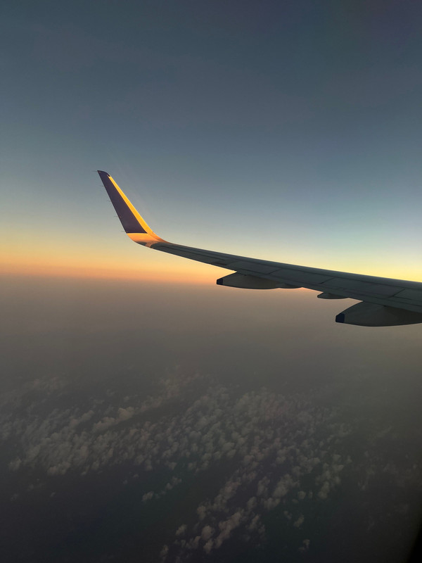 Commercial airplane taking off from runway during sunset departure